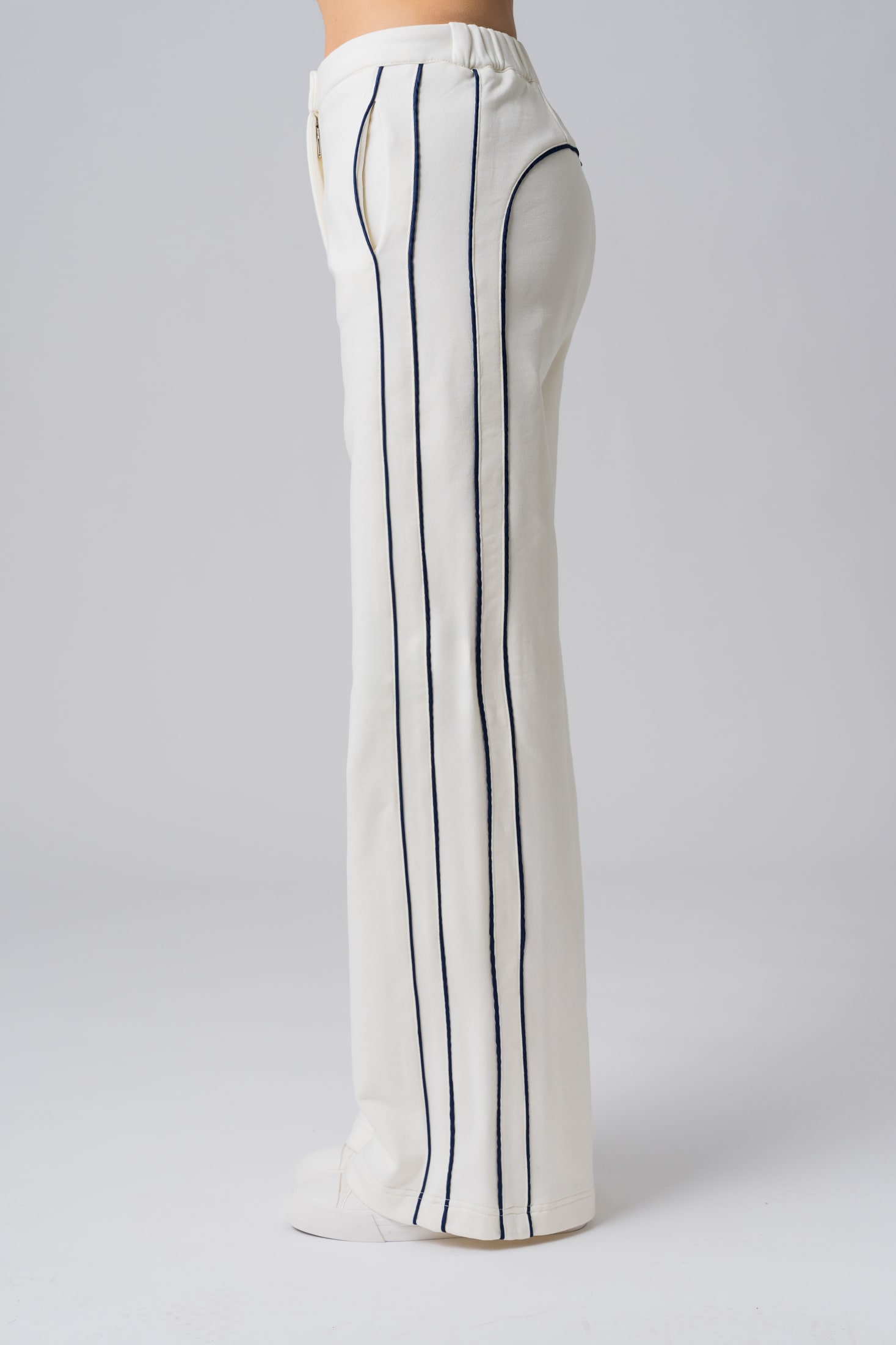 Women’s white 100% cotton high-waist sweatpants with black contrast piping and a buttoned waist