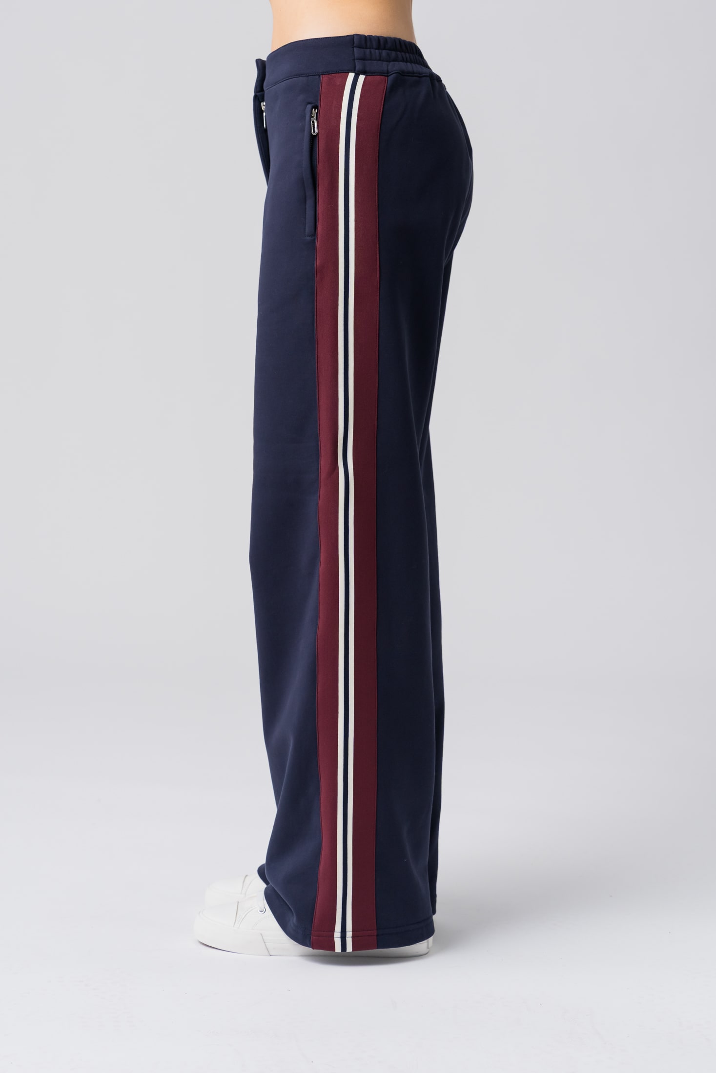 Women's navy sweatpants with red and white stripes made from 100% cotton with pockets and a zipper
