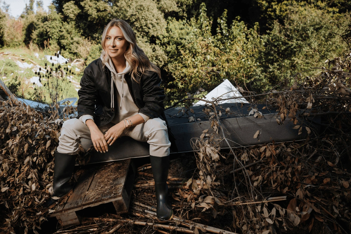 Woman wearing neutral cotton loungewear sitting outdoors, representing responsible clothing and environmental awareness.